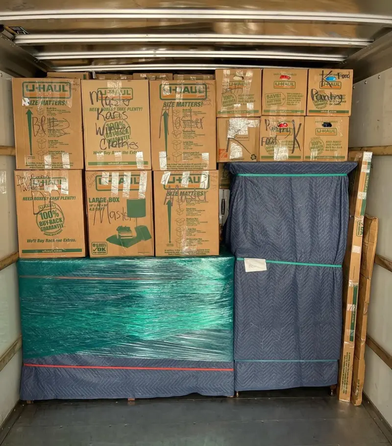 Neatly packed moving truck with labeled boxes and wrapped furniture