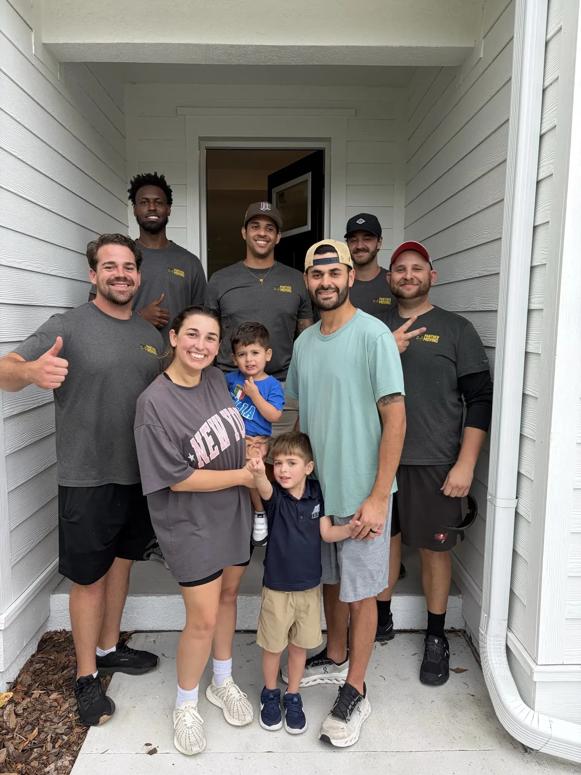 Panther Moving crew with a happy customer family after completing a move